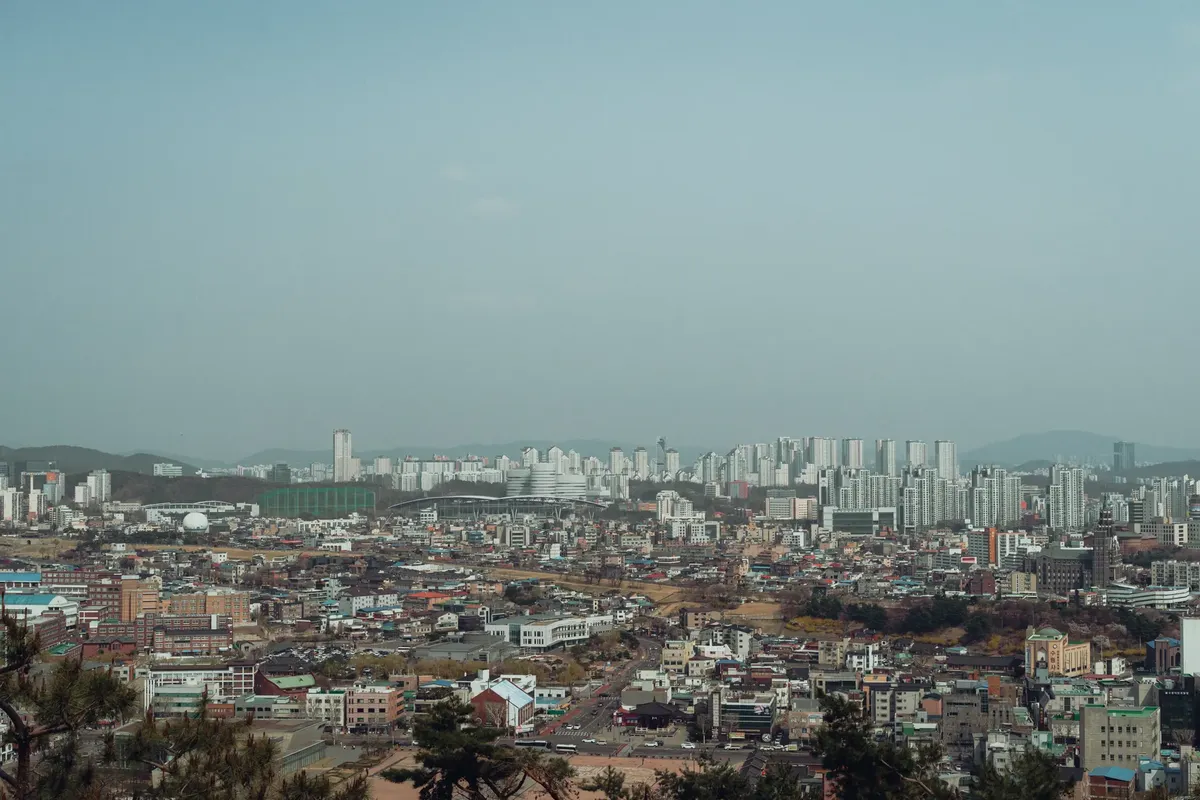A sweeping view of Seoul's urban landscape with a mix of modern skyscrapers and traditional architecture.
