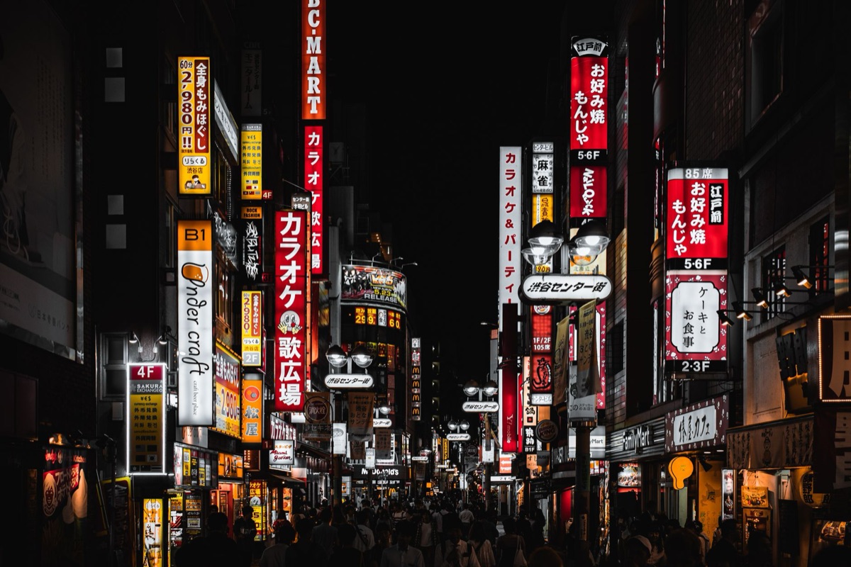Hongdae nightlife with bright lights and people walking through a lively street scene