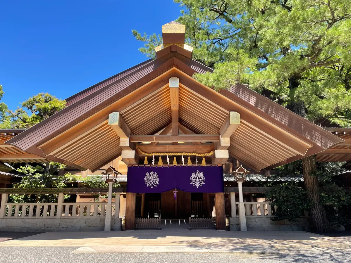 A serene view of Atsuta Jingu shrine entrance in Nagoya, Japan, under a bright blue sky.