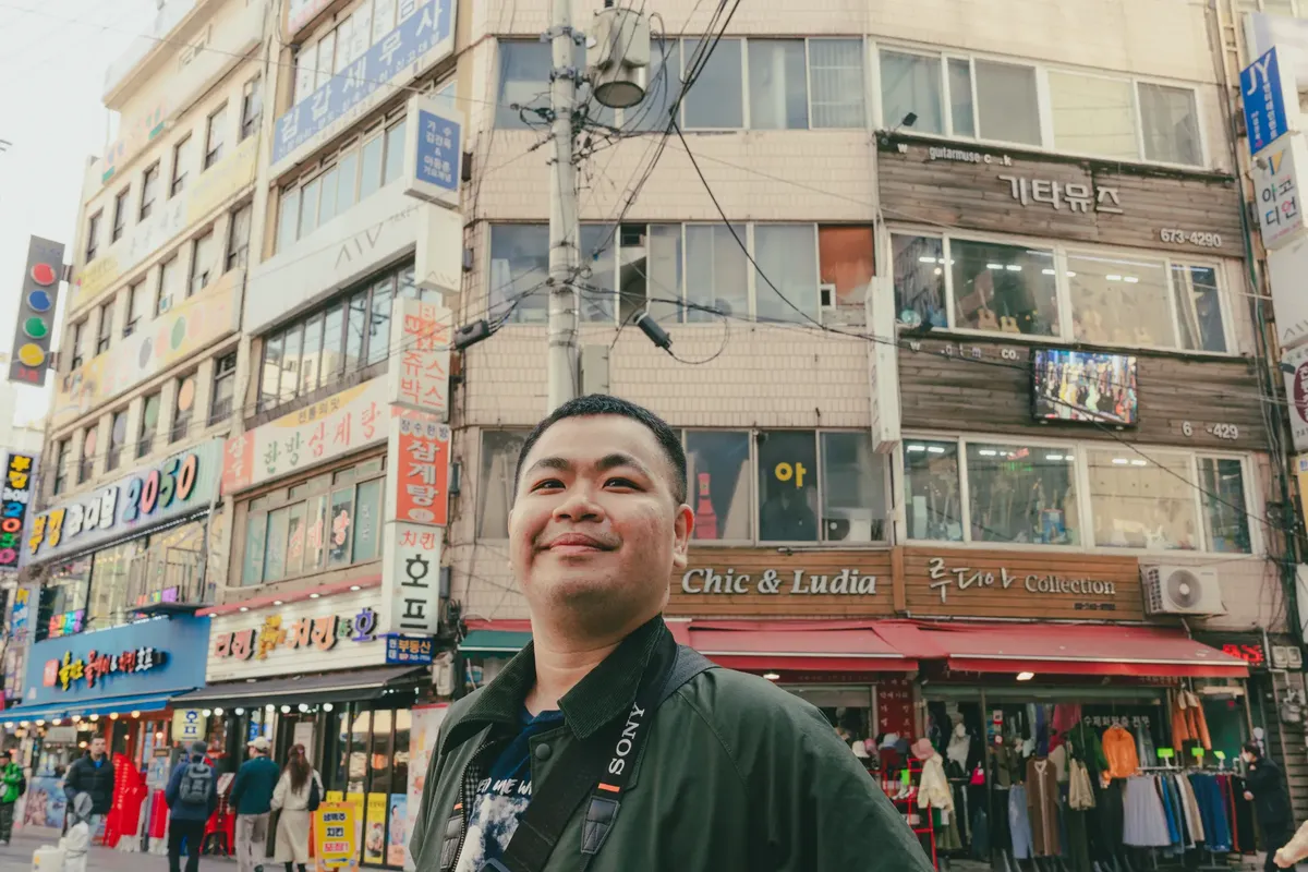Street scene in bustling Seoul with local architecture and people, capturing city life.